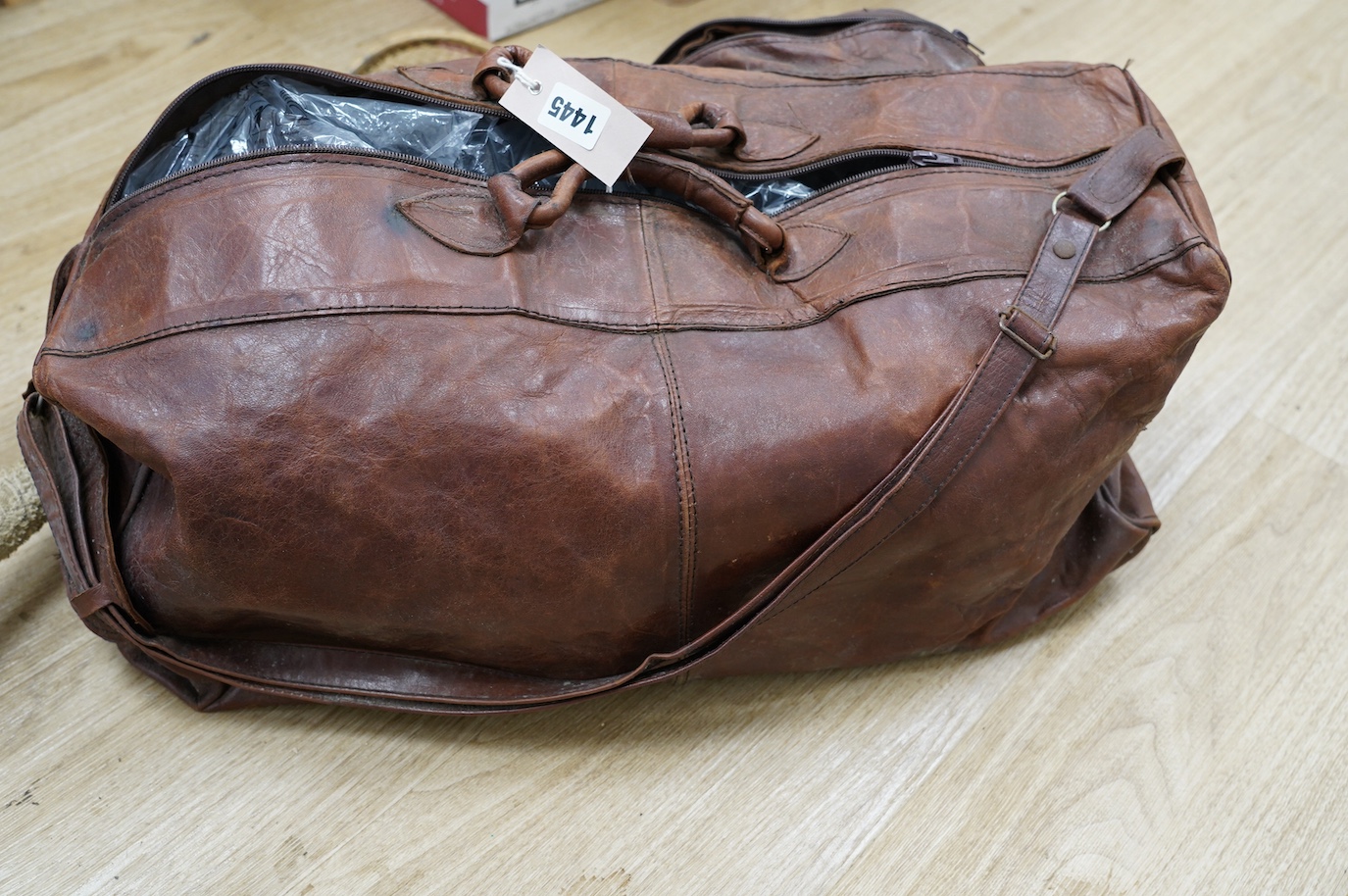 A leather sports holdall, with squash racket. Condition - poor to fair